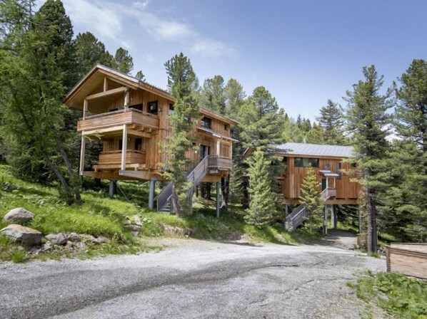 A wooden cabin complex with multiple levels, surrounded by dense forest. - # 6 mit IR-Sauna und Sprudelwanne Innen by Interhome (Turracher Höhe)