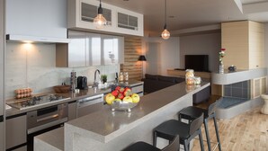 A modern kitchen with a central island, stainless steel appliances, and hanging pendant lights. - Aspect Luxury Apartments by H2 Life (Kutchan)