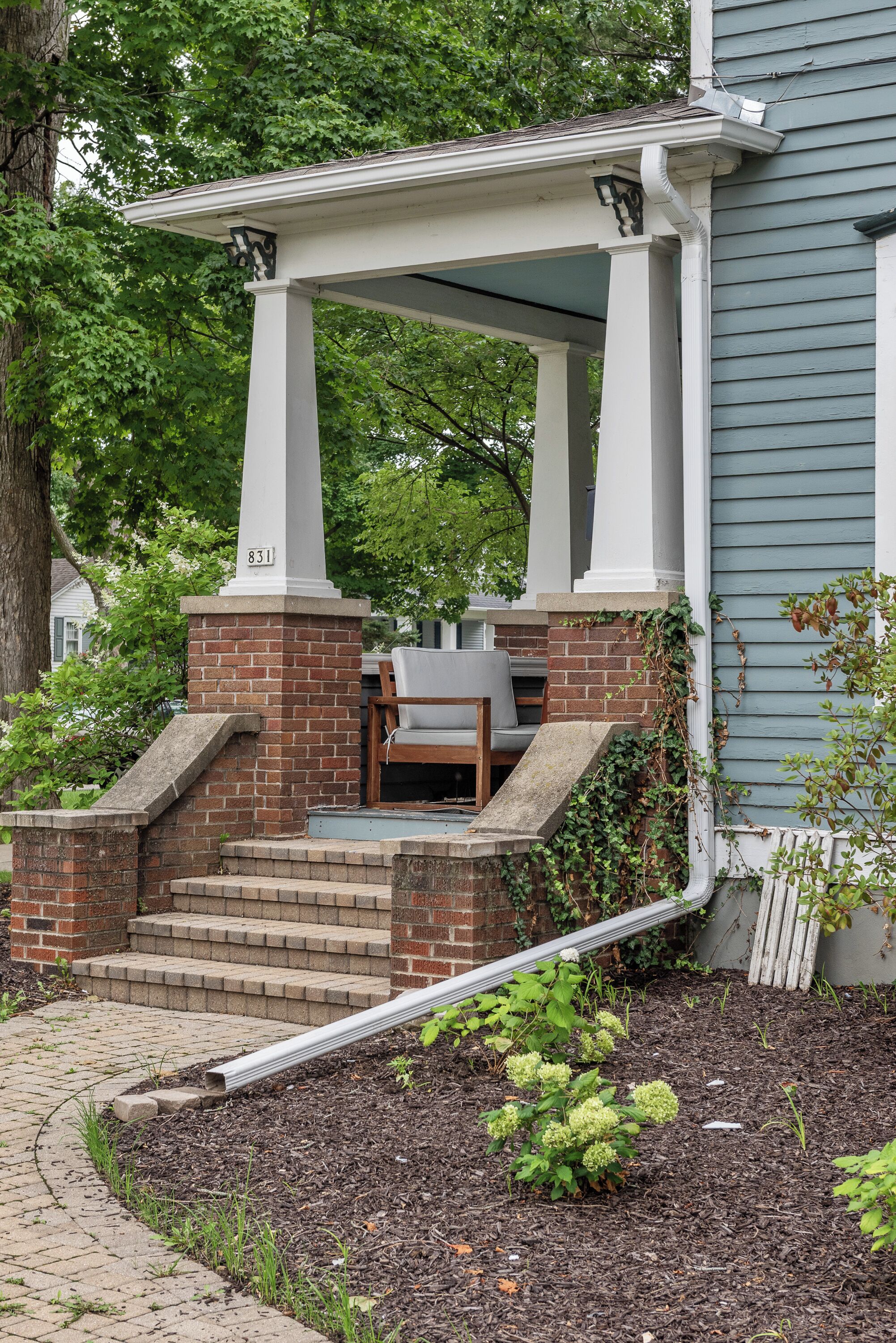 A house with a porch, brick steps, and a mailbox.