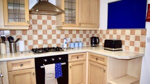 Una cucina con piano cottura a gas, forno e macchina da caffè.