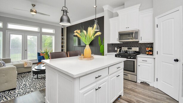 A modern kitchen with white cabinetry, a central island, and a dining area with a patterned rug. - ✵ Casa Blanca✵| Rooftop With Skyline View *  *Game Room* Private Chef (Houston)