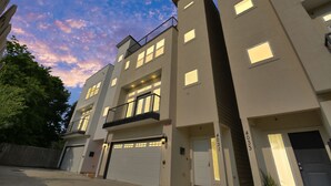 A multi-story residential building with a flat roof, large windows, and a garage door. - ✵ Casa Blanca✵| Rooftop With Skyline View *  *Game Room* Private Chef (Houston)