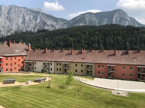 Une rangée d’immeubles à plusieurs étages, avec une chaîne de montagnes en arrière-plan.