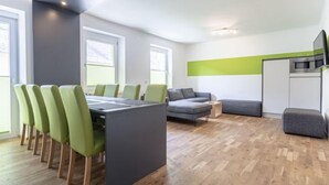 A modern living space with a dining area, a sofa, a kitchen, and a TV. - für bis zu 8 Personen mit IR Sauna by Interhome (Eisenerz)