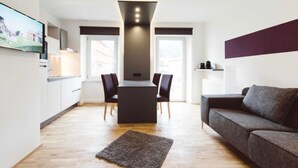 A modern living room with a sofa, a coffee table, and a TV mounted on the wall.