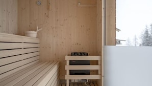 Uma sauna de madeira com bancos e um pequeno prateleira.