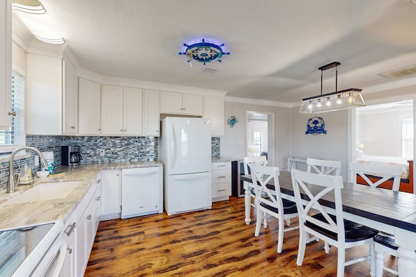 Enjoy cooking in this well-equipped kitchen with a central island, dishwasher, double sink, and stainless steel refrigerator.
