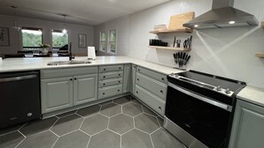 Eine moderne Küche mit einer großen Kochinsel, integriertem Backofen und sechseckigem Fliesendesign.