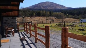 A wooden fence leading to a stone building with a dog lying on the ground. - 1 Bed Cabin in the Magical Galloway Forest Park (Newton Stewart)
