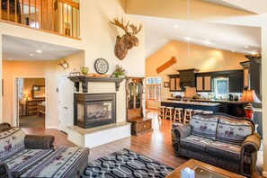 Cozy living area with a fireplace, mounted moose head, and comfortable seating.