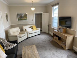 Relax in this stylish living room with a sofa, armchair, and flat-screen TV.