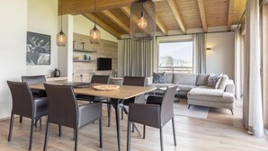 Een modern interieur met een eethoek, een bank en een keuken.