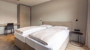 Een moderne hotelkamer met een groot bed, een bureau en een stoel.