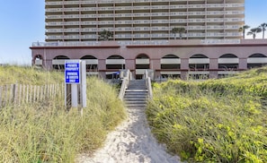 A pathway leading to a building with a sign indicating it is private property for owners and guests only. - Sunrise Beach Resort Retreat with Bunk Room and Stunning Sunrises (Panama City Beach)