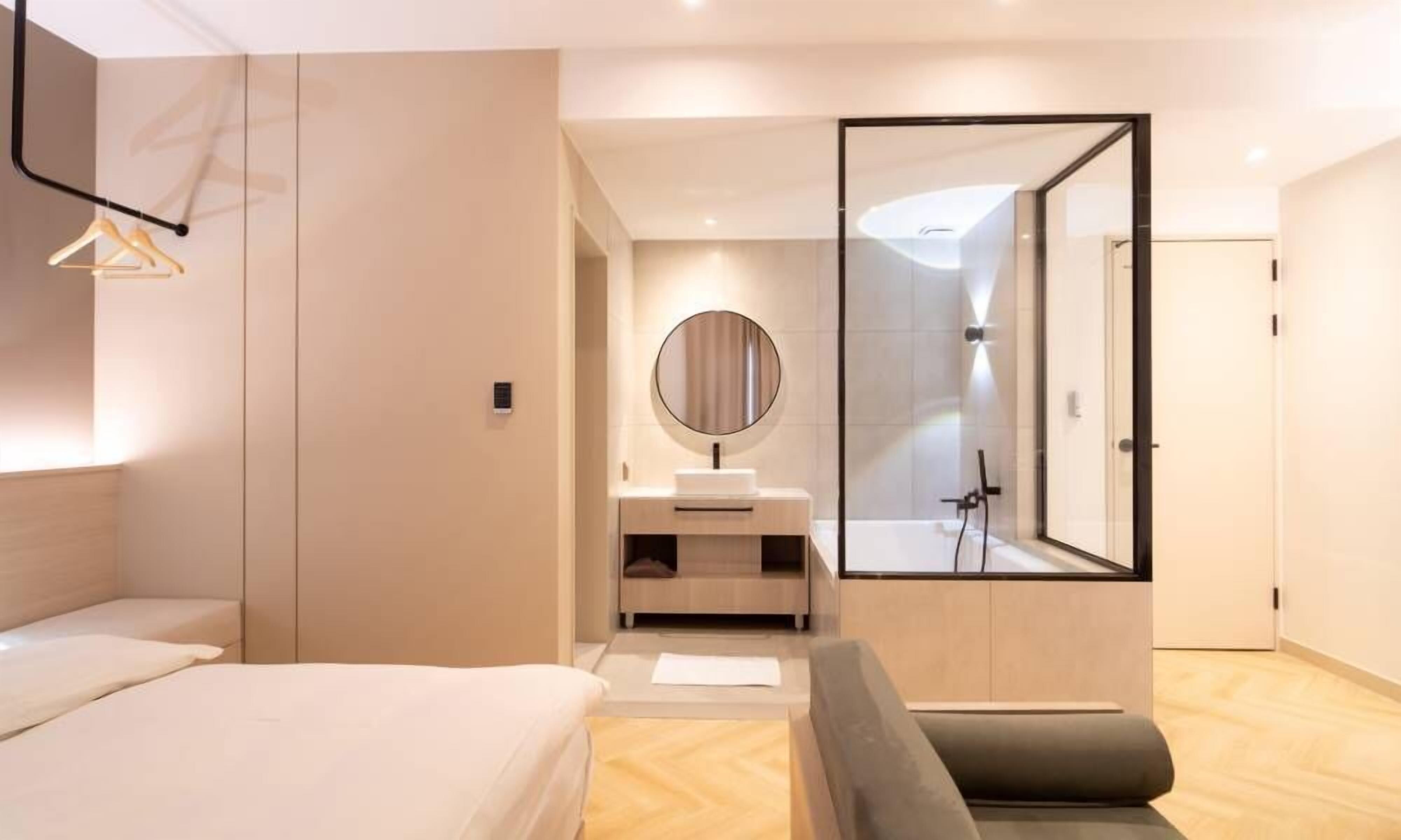 Un dormitorio moderno con una cama, una mesita de noche, un espejo y un vestidor.