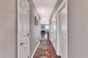 A hallway with white doors, a patterned rug, and a clock on the wall. - Treehouse 1414: Stunning Lake Views, Boat Slip Included, Free Tickets & Prime Location (Branson)