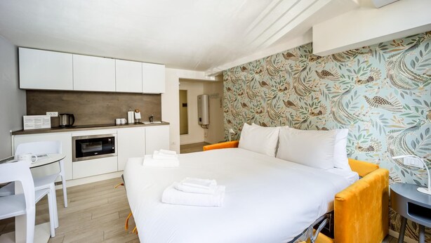 Une chambre d’hôtel comprenant un lit, un bureau, un coin cuisine et une salle de bain.