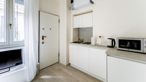A compact kitchen with white cabinets, a microwave, a kettle, and a sink. - Italianway - The B Village Standard - 02 (Milan)
