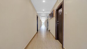 Un pasillo largo y estrecho con paredes de colores claros y suelo de baldosas.