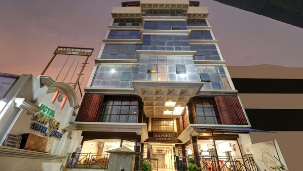 Un edificio de varios pisos con un letrero de clínica, un letrero de hotel y un anuncio para 'Kapeel Tower'.