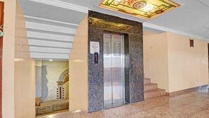 Un ascensor con un cartel que indica una capacidad máxima de 4 personas.