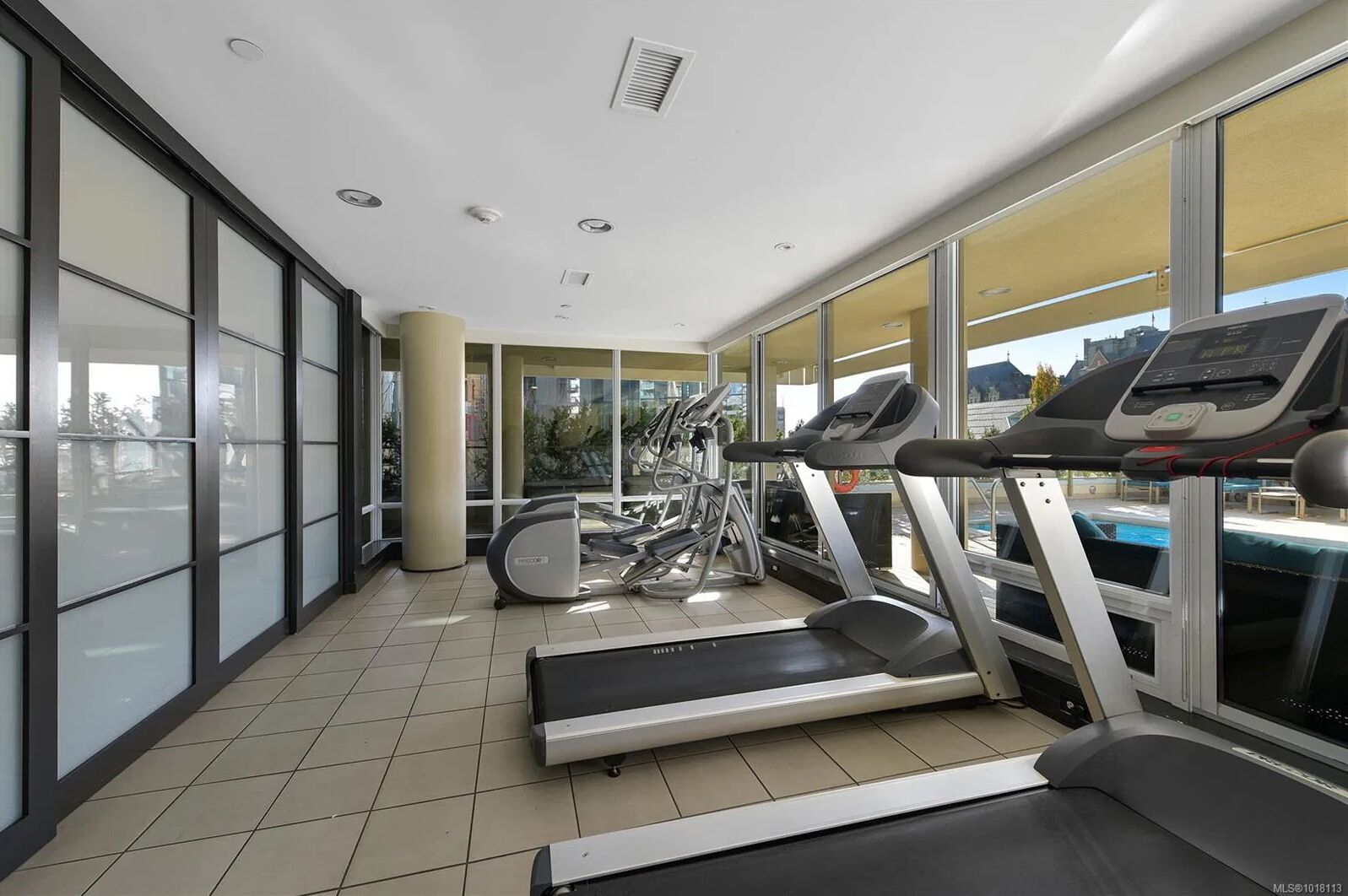 A modern gym with treadmills, stationary bikes, and a rowing machine.