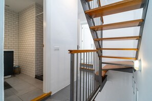 A staircase with wooden steps and metal railings, leading to a landing with a white door.