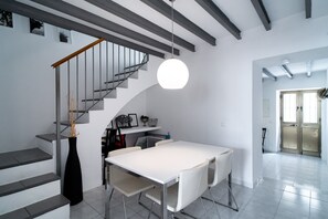 A modern interior with a staircase, a dining area, and a kitchen.