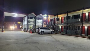 Un motel à plusieurs étages avec un parking, un McDonald's et un immeuble doté de balcons.