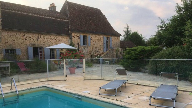 A swimming pool with two sun loungers, a covered seating area, and a stone building in the background. - Charming cottage in Périgord: Aliénor's relay (Capdrot)
