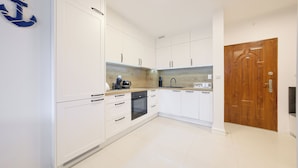 Een moderne keuken met witte kasten, een houten aanrechtblad en een ingebouwde oven.