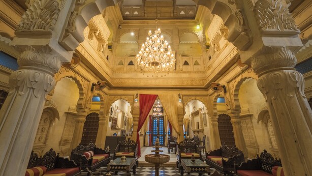 An ornate hall with intricate carvings, a chandelier, and traditional seating arrangements. - The Jaigarh Palace Jaisalmer (Jaisalmer)