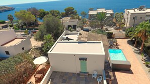 Un tetto con piscina, posti a sedere all'aperto e vista sul mare.
