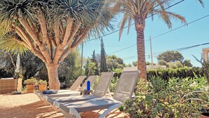 Un'area patio con poltrone, un tavolo e una bottiglia d'acqua.