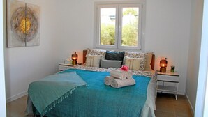 Una camera da letto con un letto, due comodini, una finestra e un quadro appeso al muro.