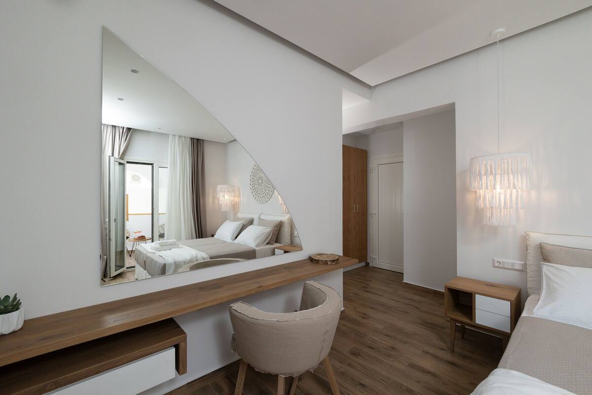 Ein modernes Schlafzimmer mit Bett, Nachttisch und einem großen Spiegel.
