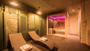 Relax in a serene sauna room with two reclining chairs and a wooden bench.