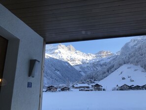 A snow-covered mountain landscape with a view of a chalet-style building.