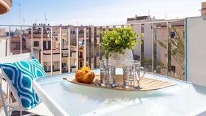 Un balcon avec une table, une plante et une pâtisserie.