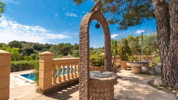 A stone fountain with a bird sculpture, a pool, and a stone balustrade. - Capella Rubi by Interhome (Artà)