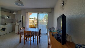 A compact living space with a kitchen, dining area, and a balcony with a view. - Port FREJUS Studio with sleeping area of ​​30 m2 for 2 Adults 2 Children with quiet balcony on the garden side (Fréjus)