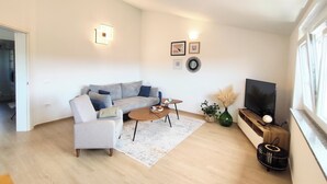 A modern living room with a sofa, coffee table, and TV.