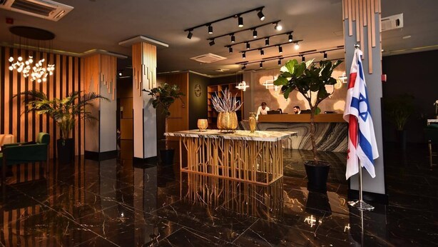 A modern lobby with a reception desk, a flag, and a bar area. - King Solomon Hotel Batumi (Batumi)