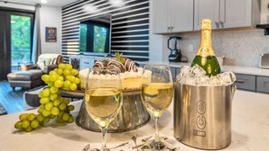 Una cocina moderna con comedor, una botella de champán, hielo y copas.
