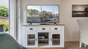Televisor muntat sobre un moble amb vista al port esportiu.