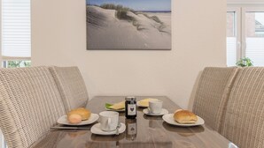 Ruokapöytä, jonka päällä on lautasellisia ruokaa, kahvikuppi ja vesipullo.