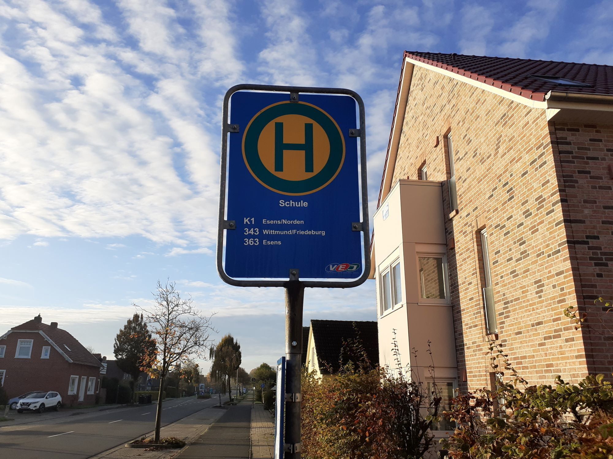 Een blauw bord met een geel 'H'-symbool en tekst die richtingaanwijzingen naar verschillende locaties geeft.