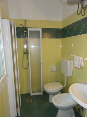 Bathroom features a shower enclosure, two toilets, and a sink with a mirror.
