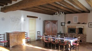 Ein Essbereich mit Holztisch, Stühlen und Kamin.
