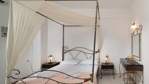 A four-poster bed with a canopy, two bedside tables with lamps, a mirror, and a dresser. - Haris Villas (Viannos)